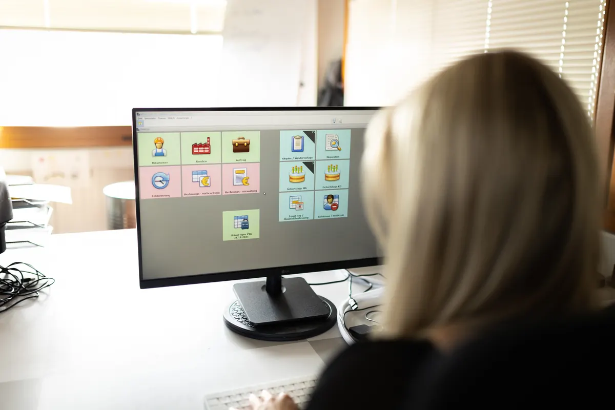 Mitarbeiterin arbeitet am PC mit der Software Attina