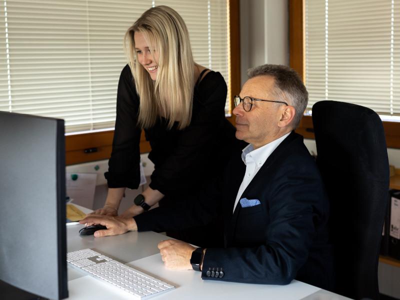 Businessmann und junge Frau vor einem Computer