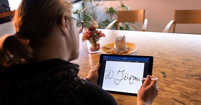 junger Mann unterschreibt auf einem Tablet